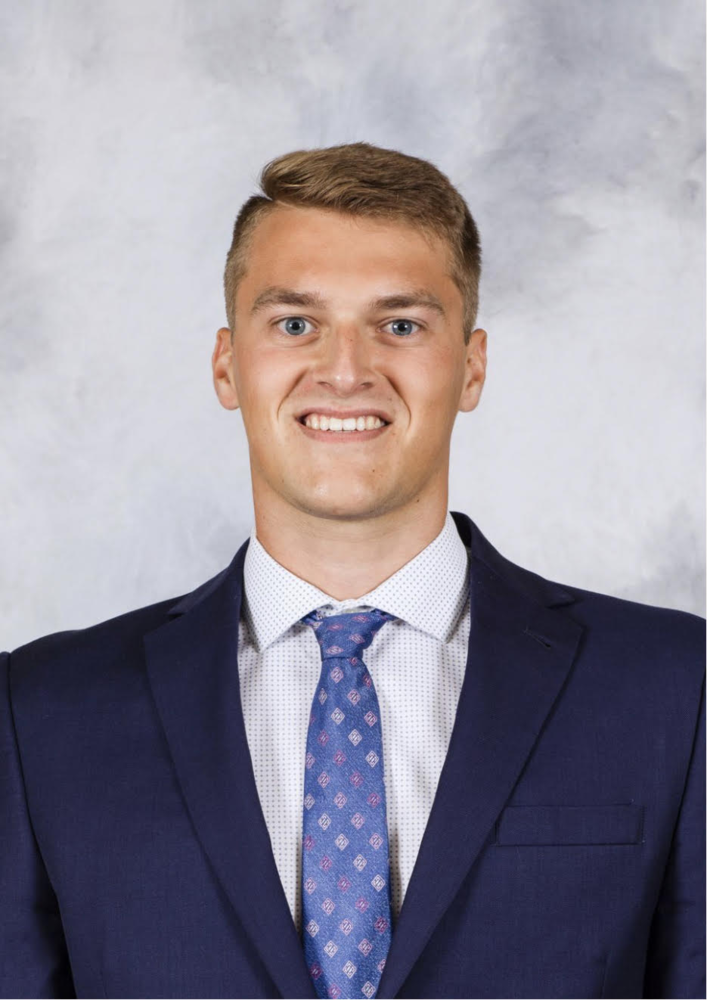 image of paxton mohr. light brown hair, caucasian male wearing a navy suit and light blue tie