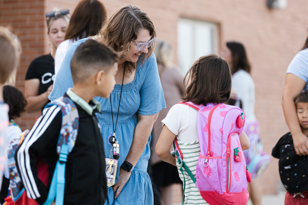 Two students talk to a North Park paraprofessional while in line for the first day of kindergarten.