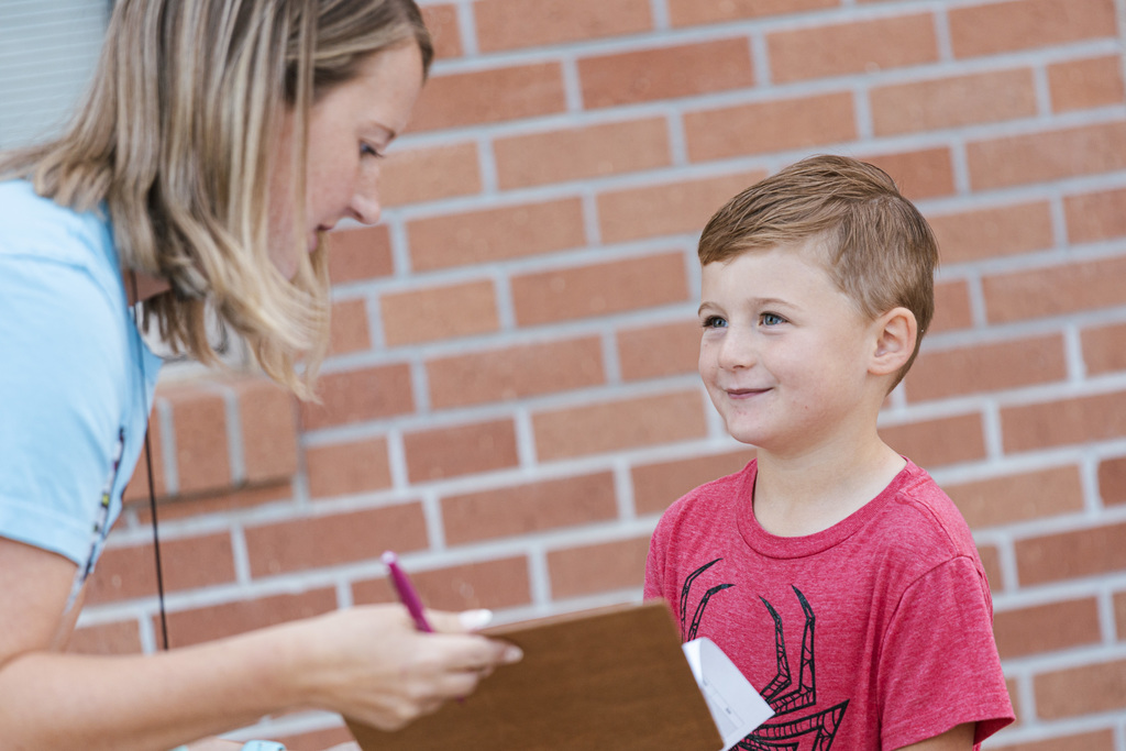 A North Park kindergarnter smiles as his teacher, Ms. Goening checks his name on a list. It was the first day of school at North Park.