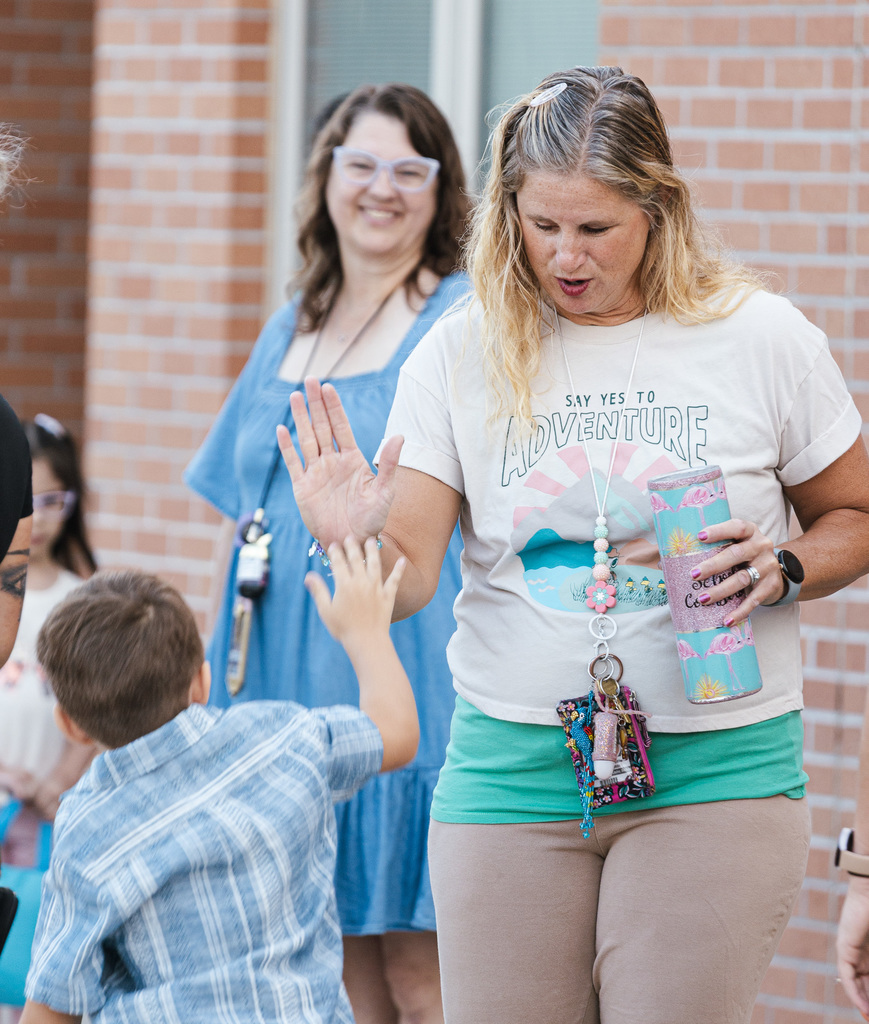North Park counselor Trine Gentile gives a high five to a student while in line for the first day of kindergarten.