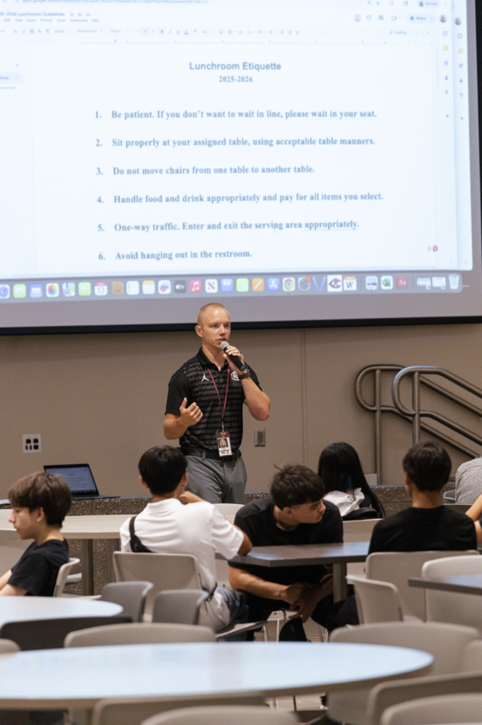 Assistant Principal Michael Ziola reviews the lunchroom etiquette items with a group of freshmen. 