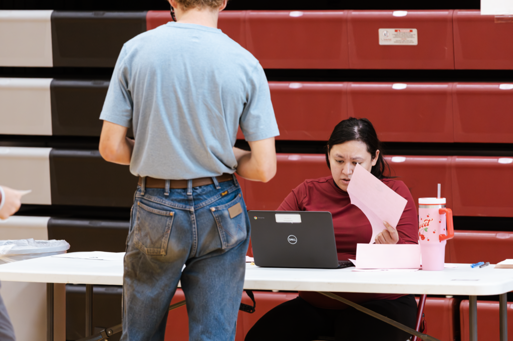 A CHS staff member assists a student during sophomore orientation at Columbus High School. 