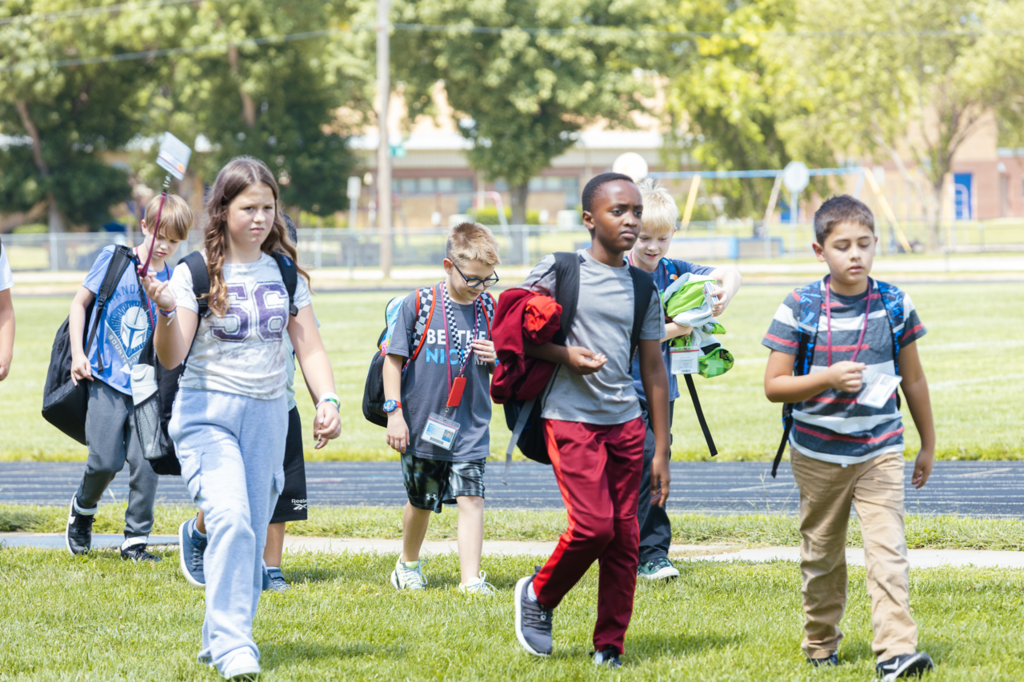 CMS 5th-graders return from ALO time, carrying their bookbags and wearing their IDs while walking outside.