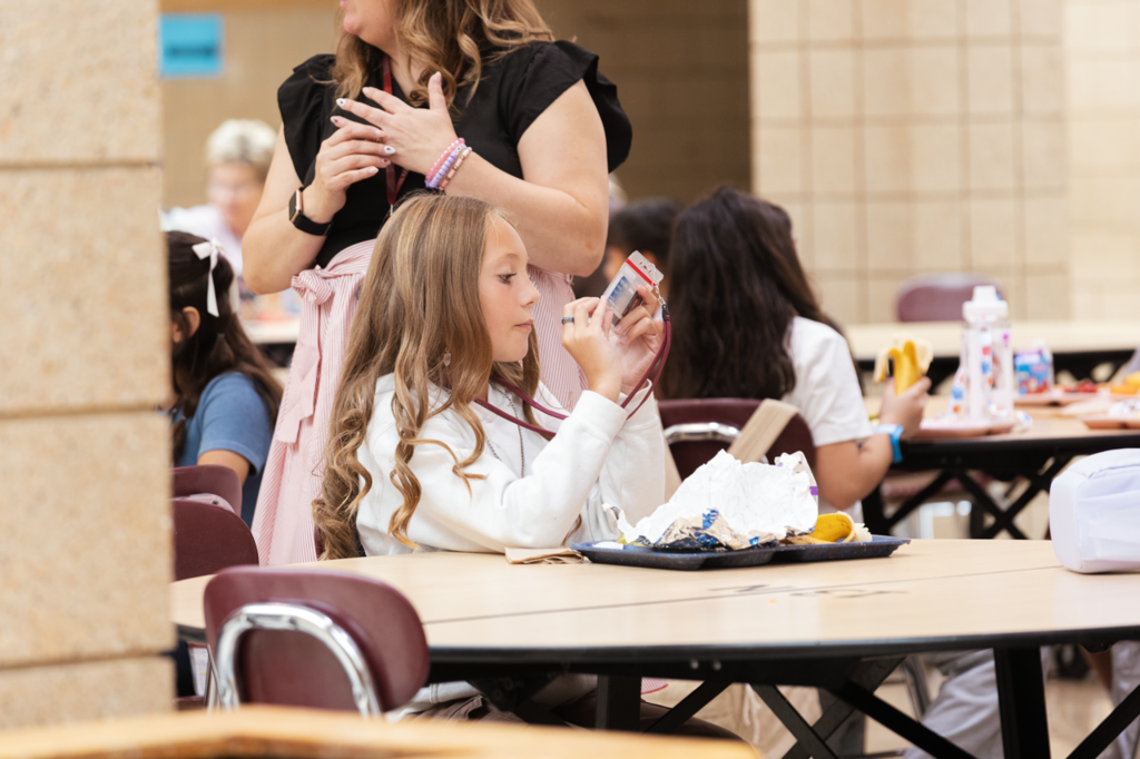 A CMS 5th-grader looks at the back of her ID during lunch on her first day.