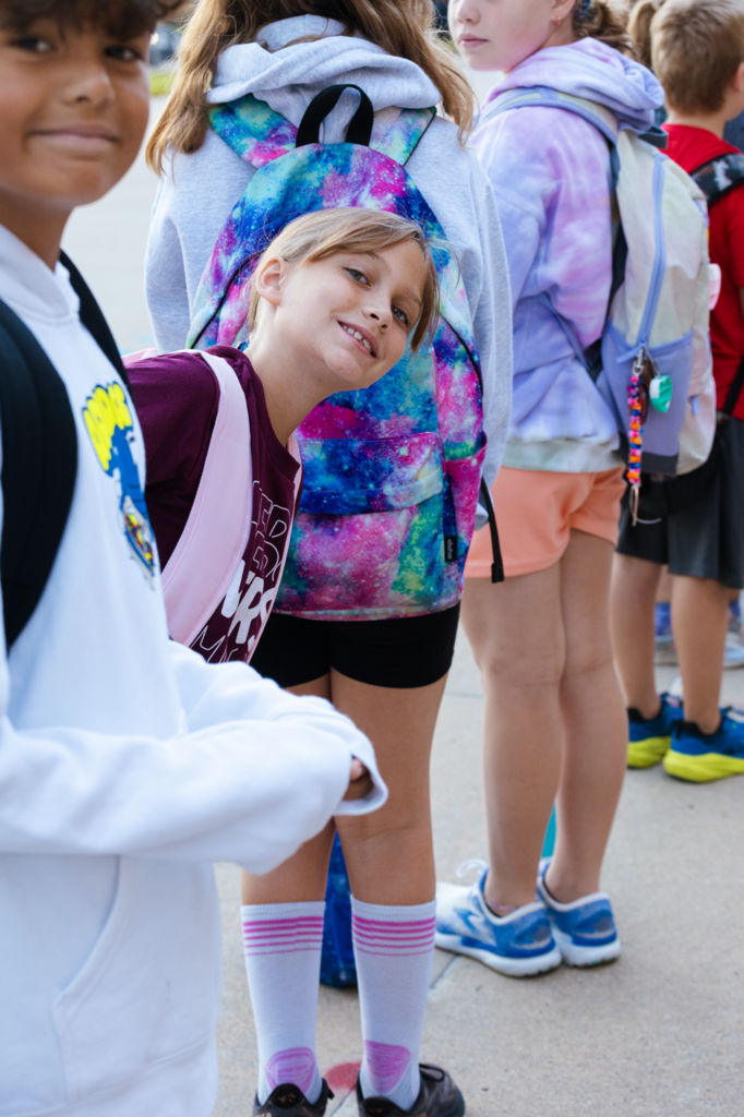 Two Emerson students smile for a photo while waiting to be led inside before the first day of school in 2025.