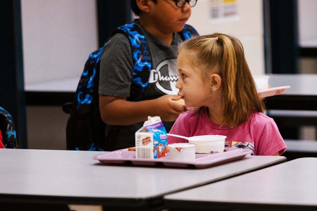 An Emerson student listens to her friends talk while eating breakfast on their first day of school 2025.