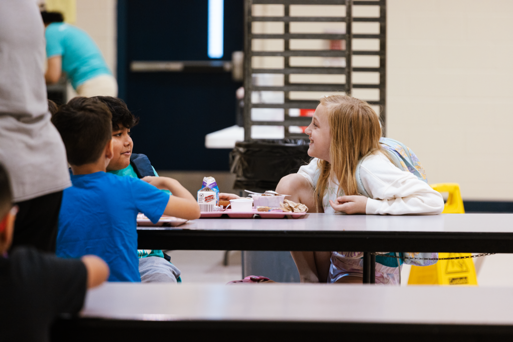 A group of Emerson students talk during breakfast in the cafeteria before the first day of school in 2025.