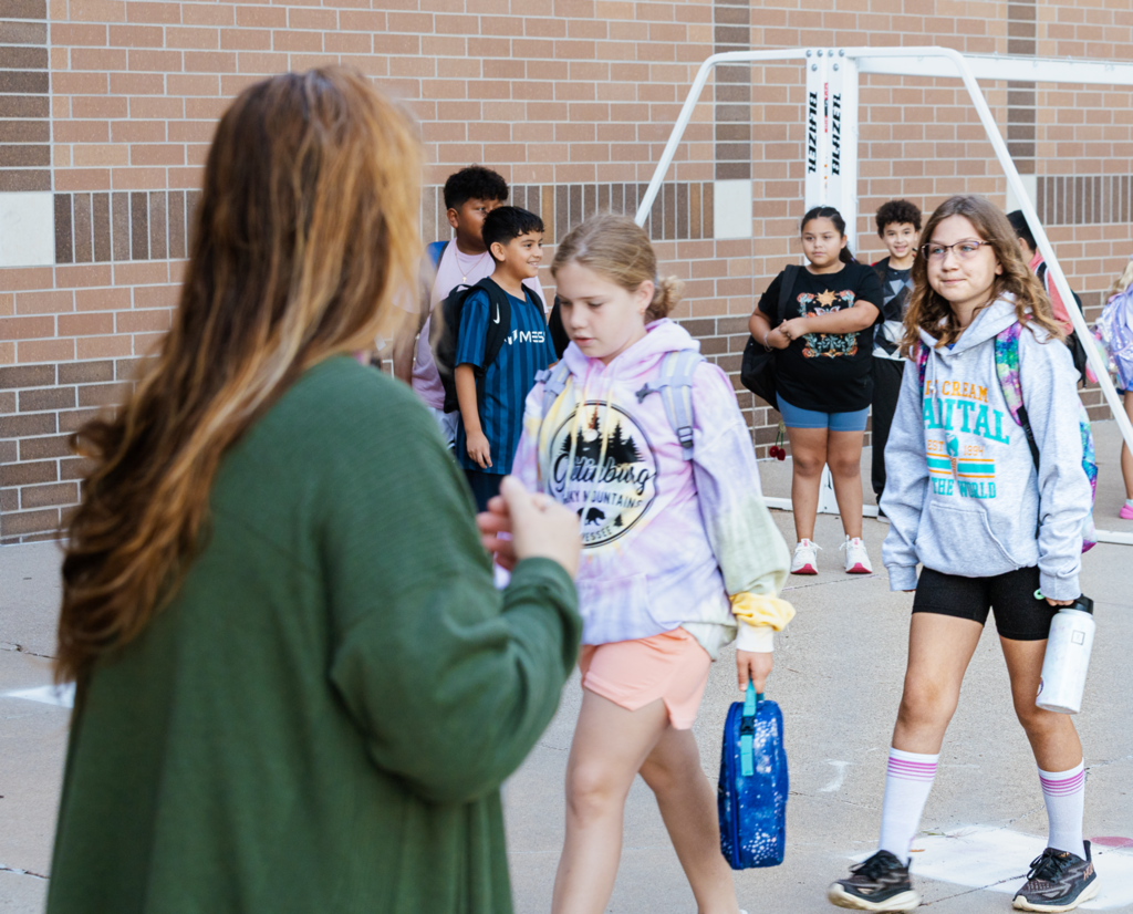 Lines of Emerson 4th graders are led inside before the first day of school in 2025.