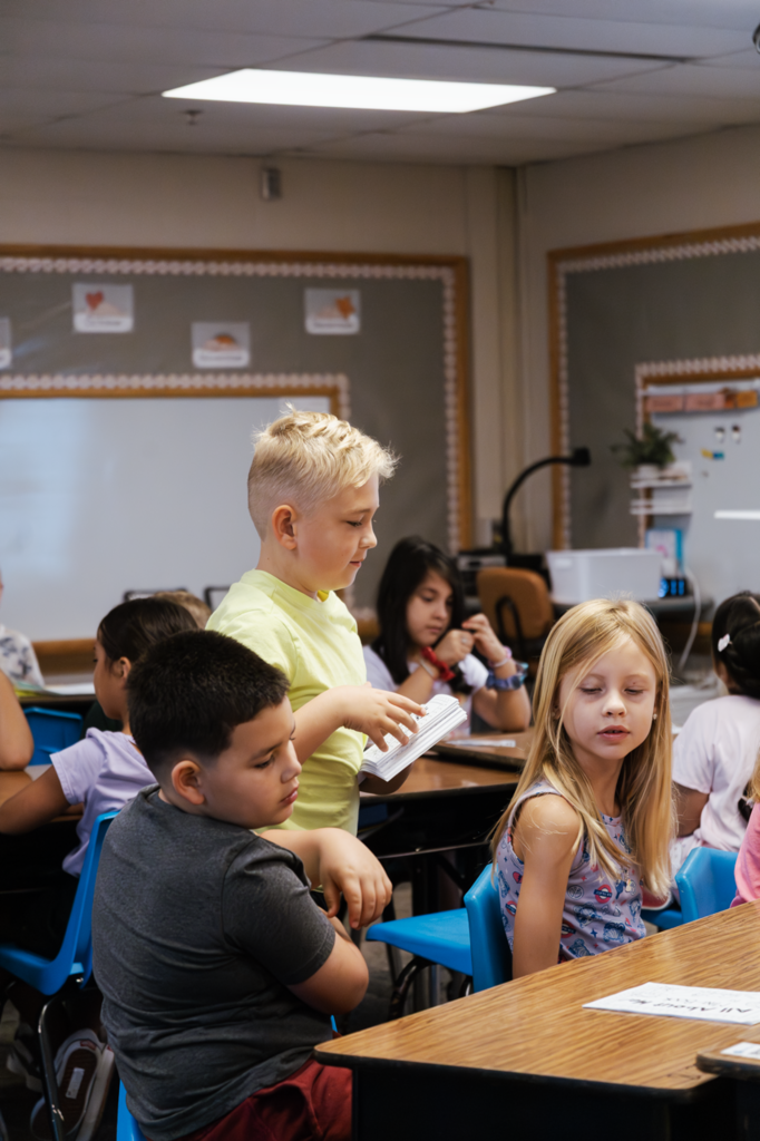 A boy in Ms. Grossnicklaus hands out the class assignment during their first day at West Park.