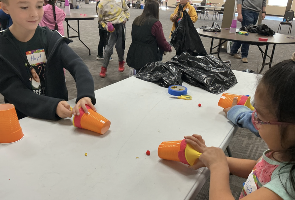 1J students using their vortex cannons to move pompoms.