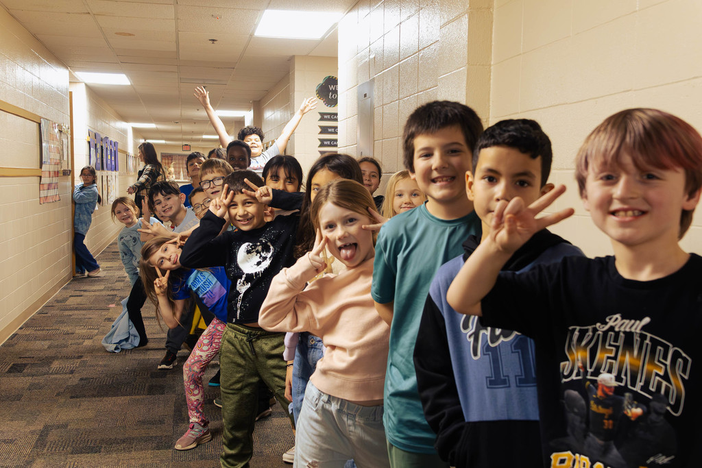 a class of students striking a pose as they are lined up to head to their next class