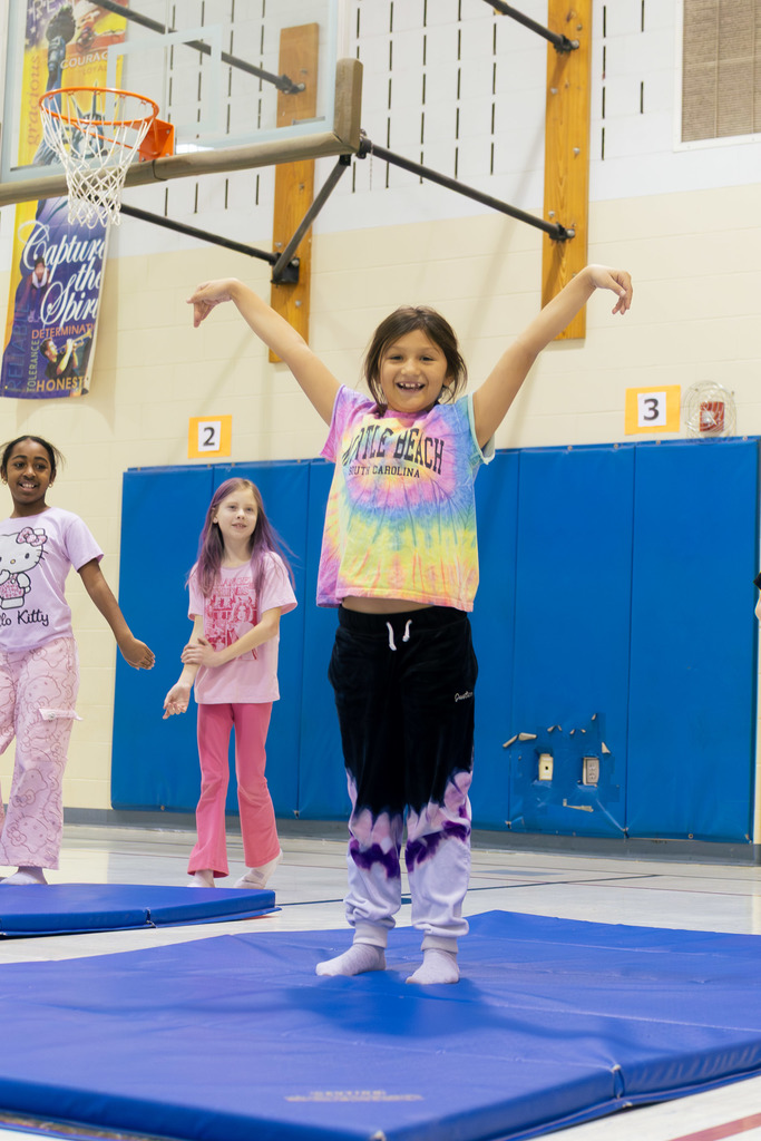 A student showing their finish pose during the gymnastics unit in physical education class