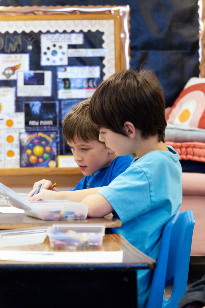 two male students coloring an assignment in their classroom