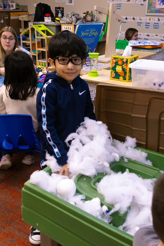 male student playing at the sensory table
