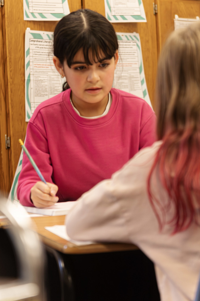 student working in their workbook to complete their assignment during class