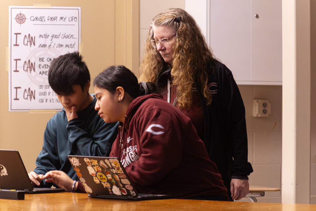 STEM teacher working with students in their lab