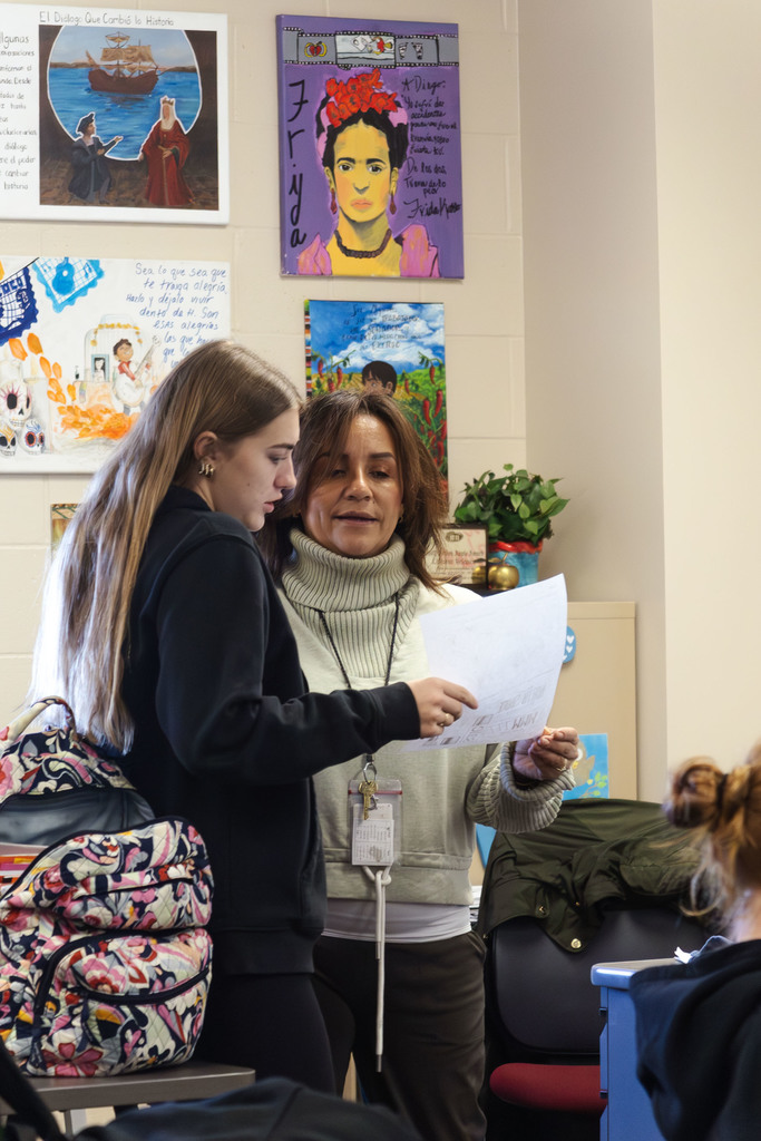 student reviewing answers with Mrs. Velasco in spanish class