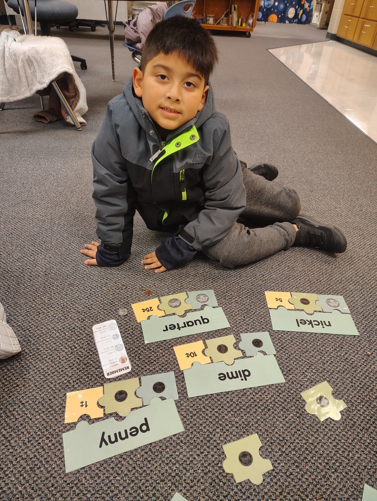Male student working on identifying coins through a completed puzzle activity.