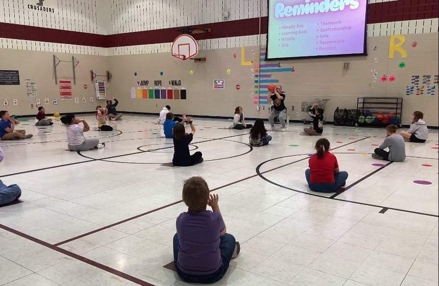Coach showing students how to shoot a basketball