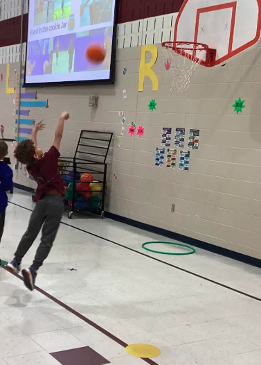 Student shooting a basketball into a hoop