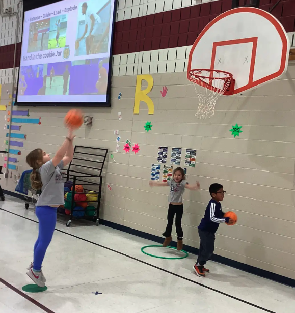 A student shooting a basketball into a hoop