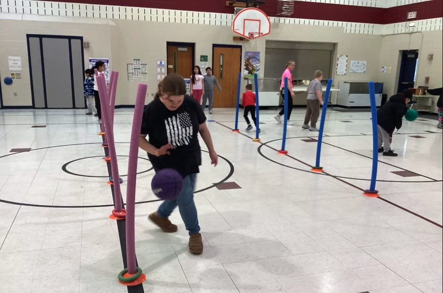 A student dribbling a basketball 