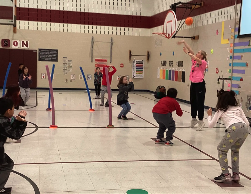 Coach Harrison teaching third grade students how to "load and explode" when shooting hoops