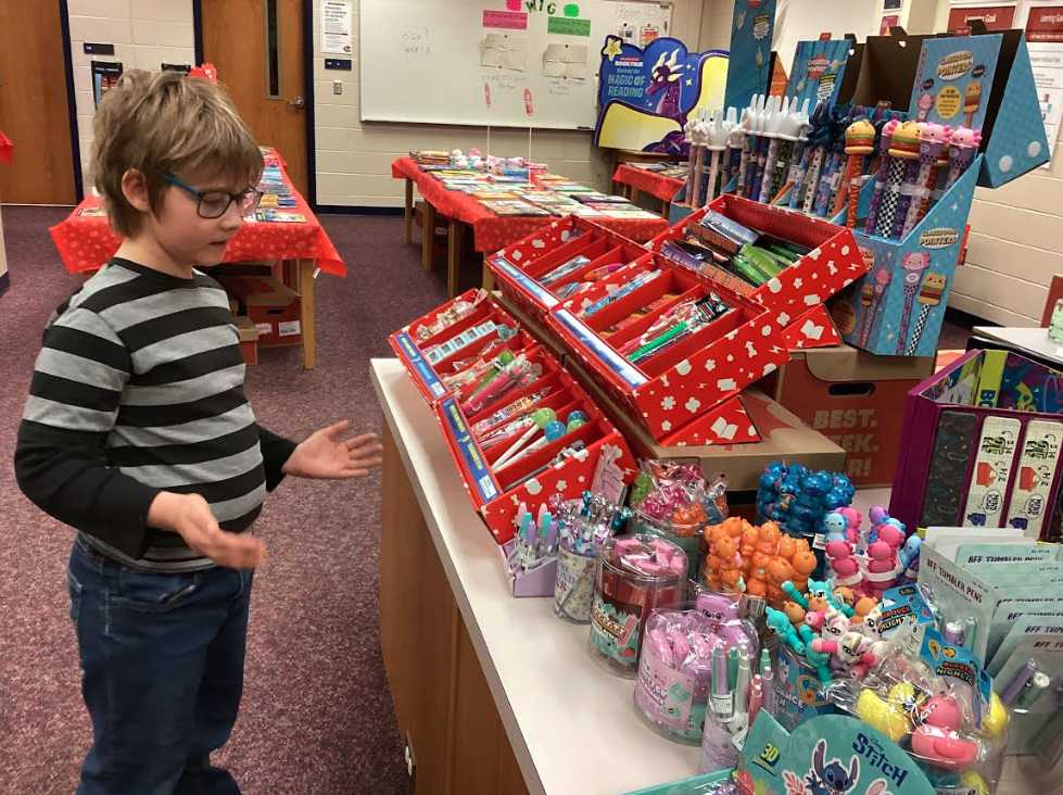 Student shopping for pencils and pens at the book fair
