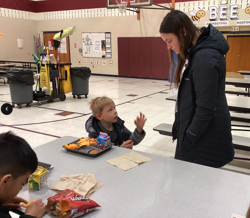 Ms. Nitz talking with a student in the lunchroom