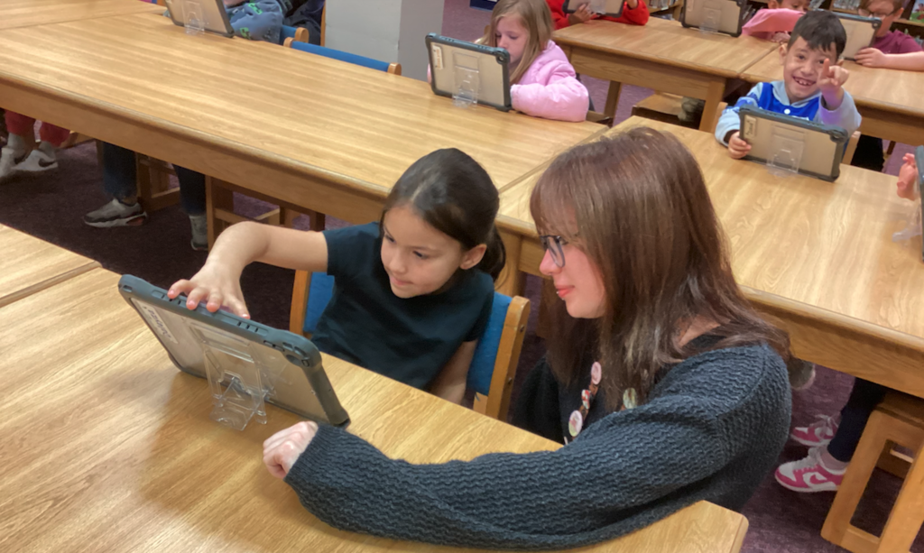 Ms. Johnson helping students in media class