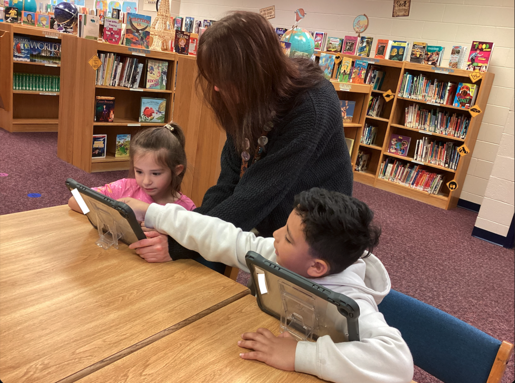 Ms. Johnson helping students in media class