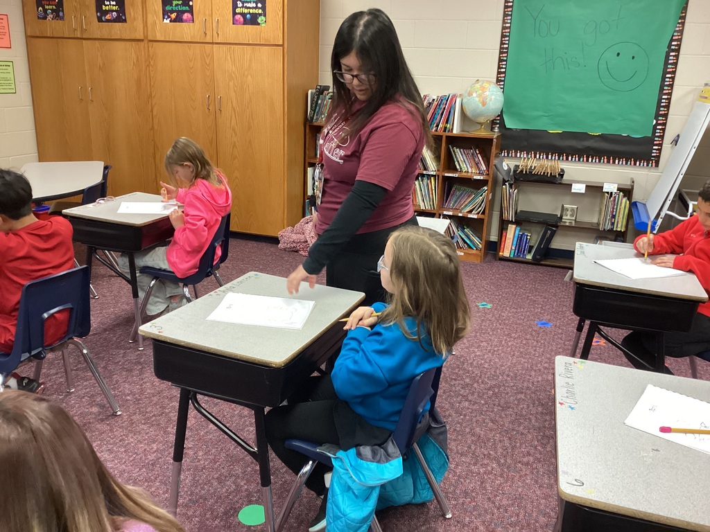 Ms. Torres helping a student during an art lesson