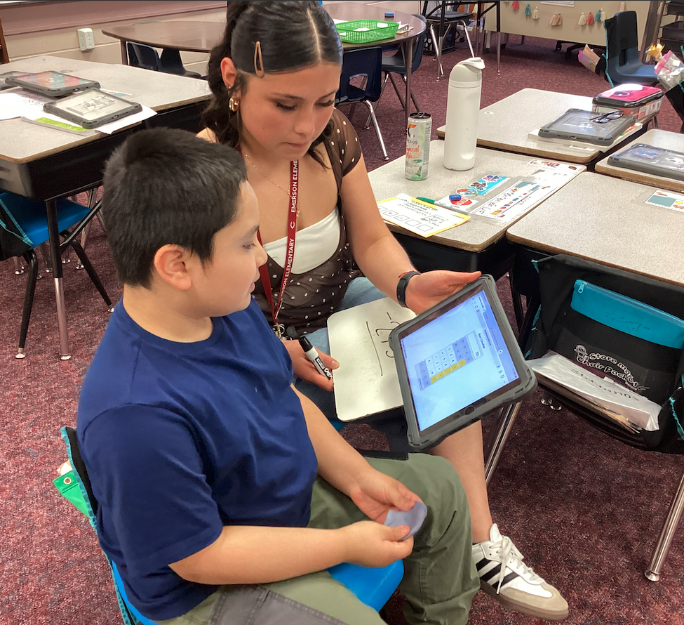 Ms. Mendoza helping a second grade student