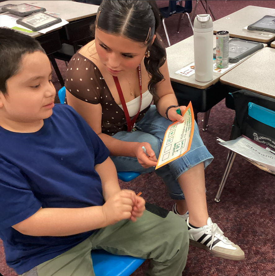 Ms. Mendoza helping a second grade student