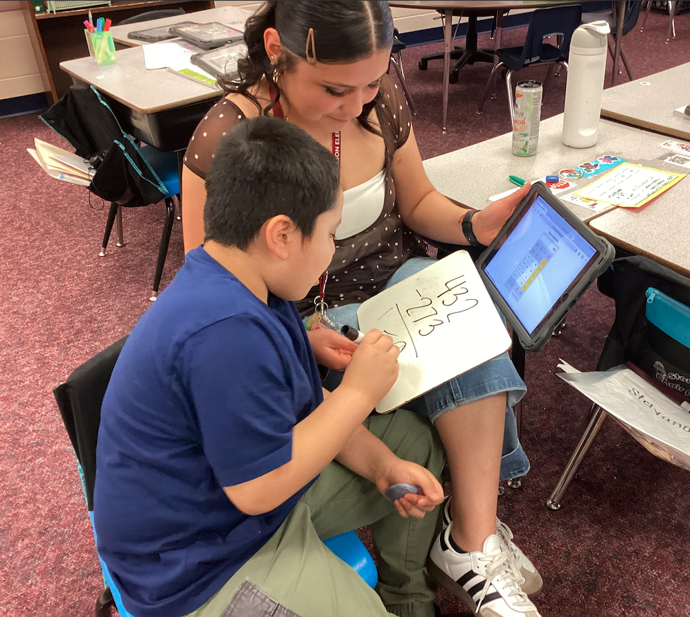 Ms. Mendoza helping a second grade student