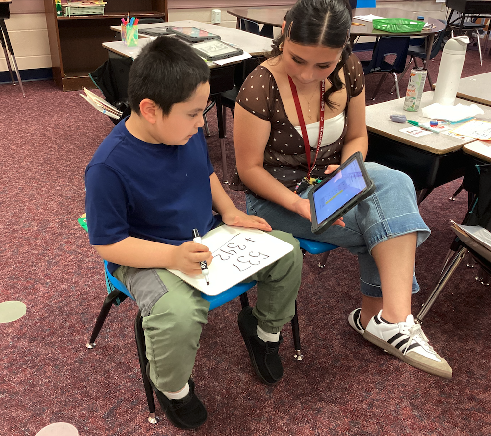 Ms. Mendoza helping a second grade student