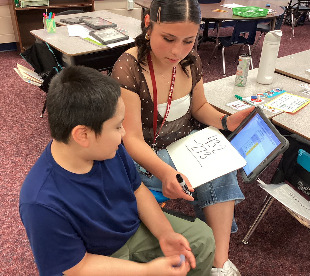 Ms. Mendoza helping a second grade student