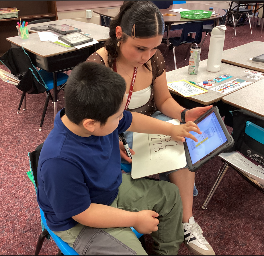 Ms. Mendoza helping a second grade student
