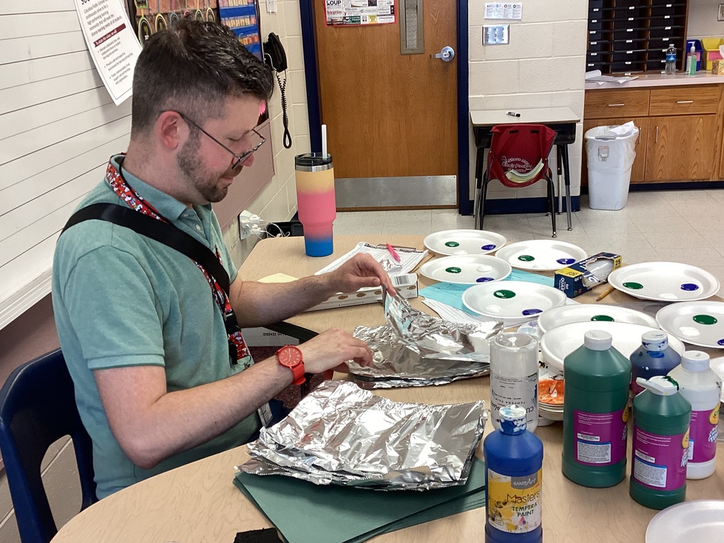 Mr. Brant preparing supplies for an art lesson