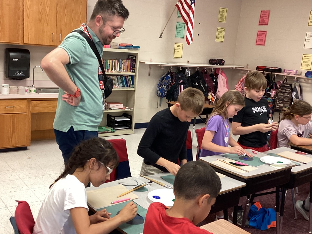 Mr. Brant watching over fourth grade students as they create art