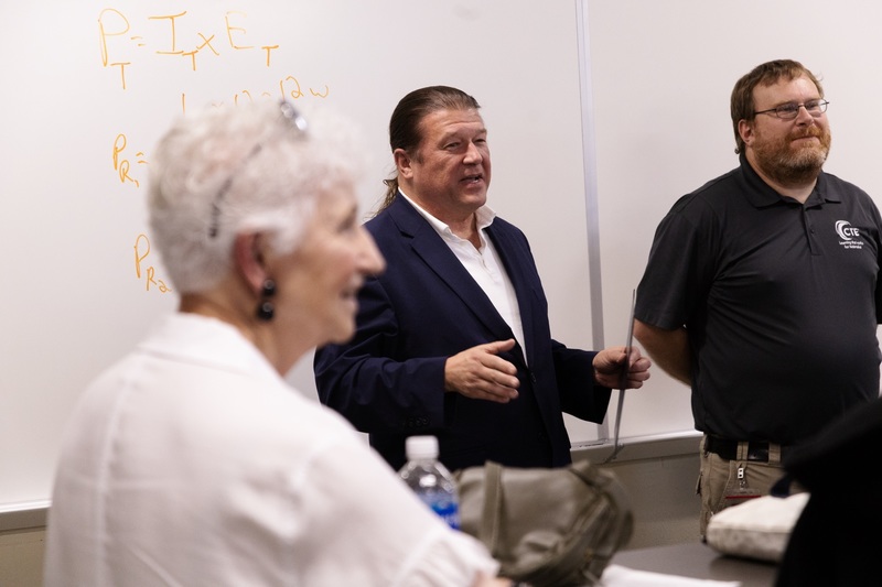 Chris Canada, AFA state level president, smiles as he discusses an award. CHS teacher Adam Whitmore is standing next to him. Diane Bartels in out of focus in the foreground.