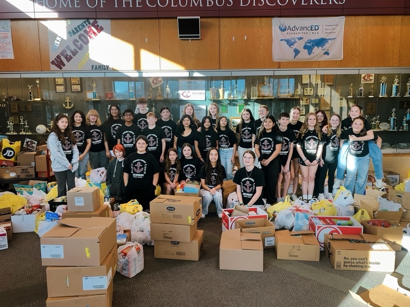 A large group of CMS Student Council members pose in front of their food drive donations. Donations totaled more than 3,300 pounds.