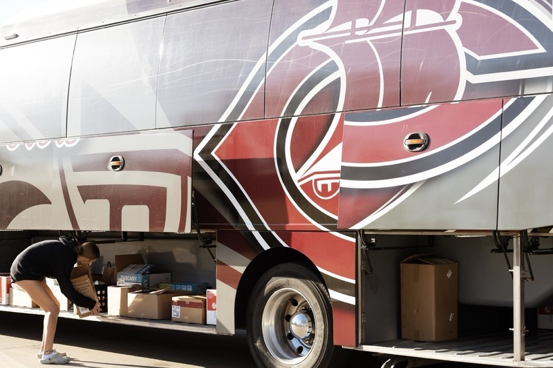 A CMS student council members loads donated items under the Columbus Public Schools touring bus.
