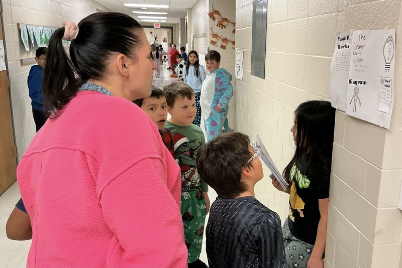 Student explaining his invention to peers.