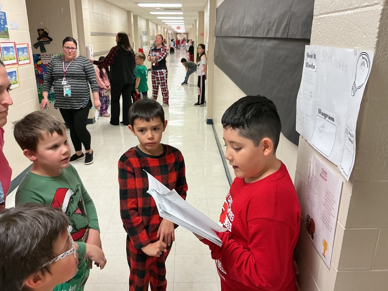 Student explaining his invention to peers.