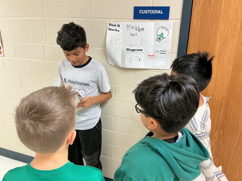 Student explaining his invention to peers.