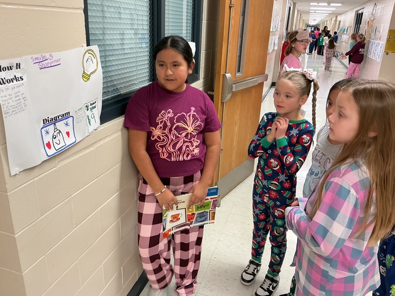 Student explaining his invention to peers.