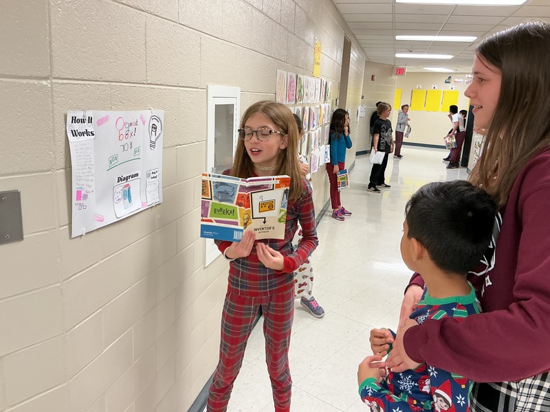 Student explaining his invention to peers.