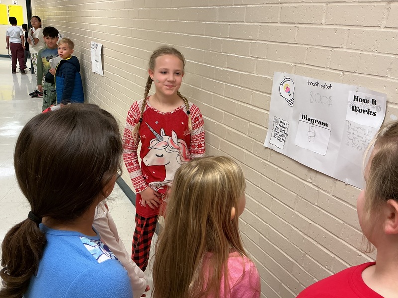 Student explaining his invention to peers.