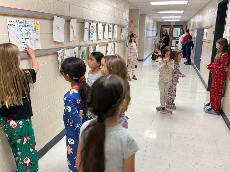 Student explaining his invention to peers.